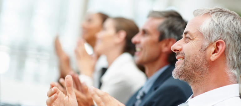 Group of happy business people clapping their hands